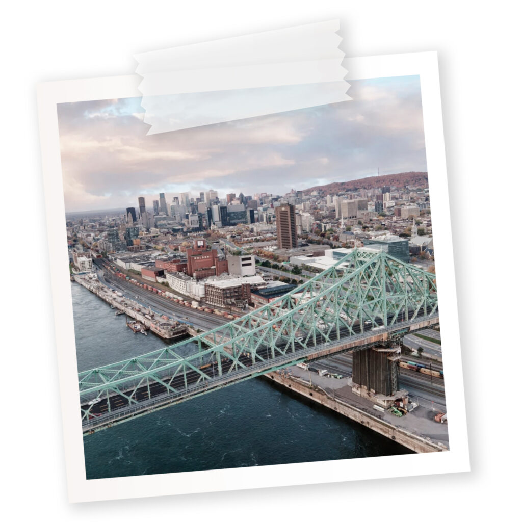 A polaroid of a desaturated version the city of Montreal with a bridge in view.